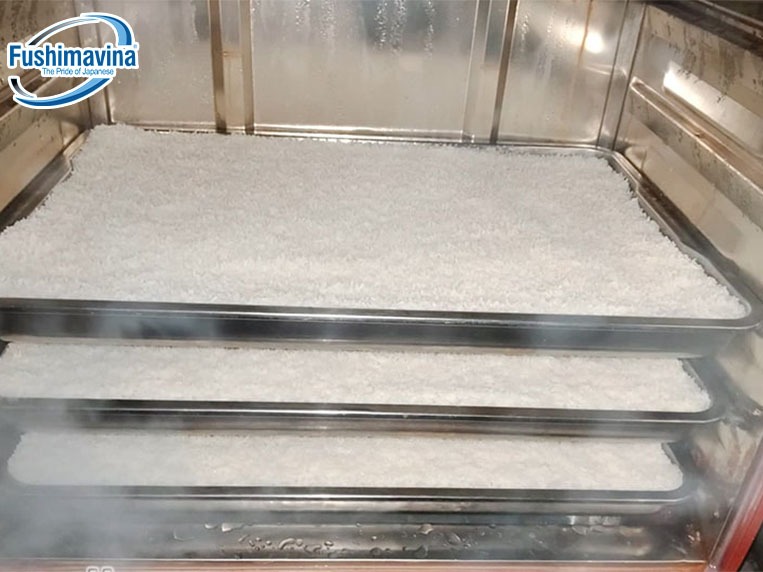  Xếp các khay chứa gạo vào tủ nấu cơm, bắt đầu quá trình nấu